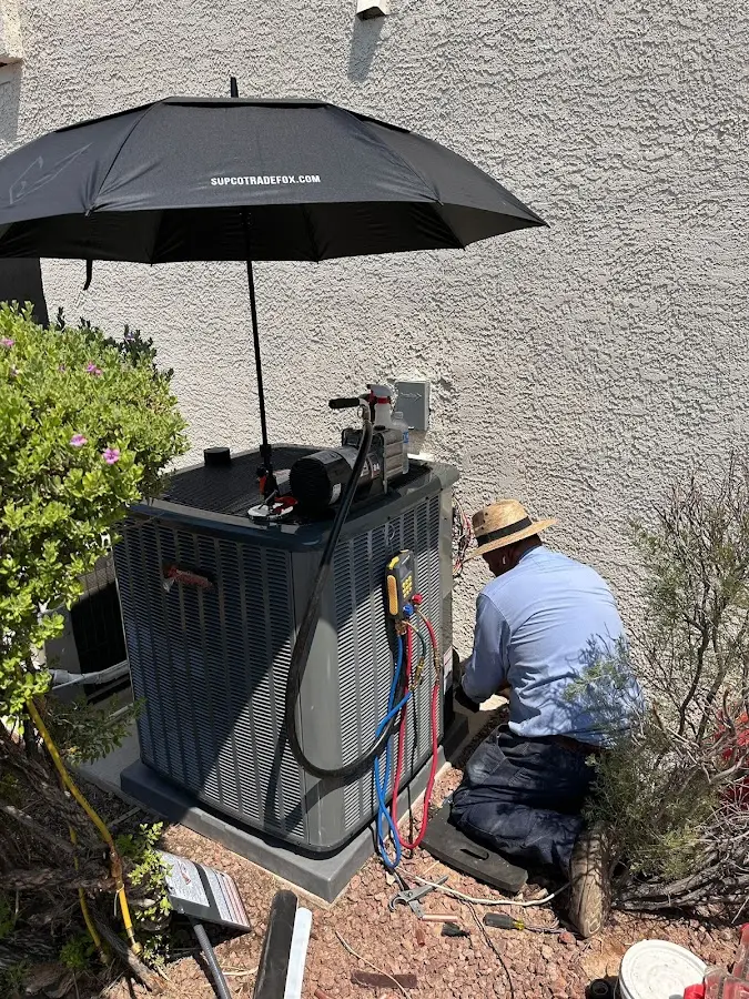 HVAC technician performing outdoor AC maintenance in Gates
